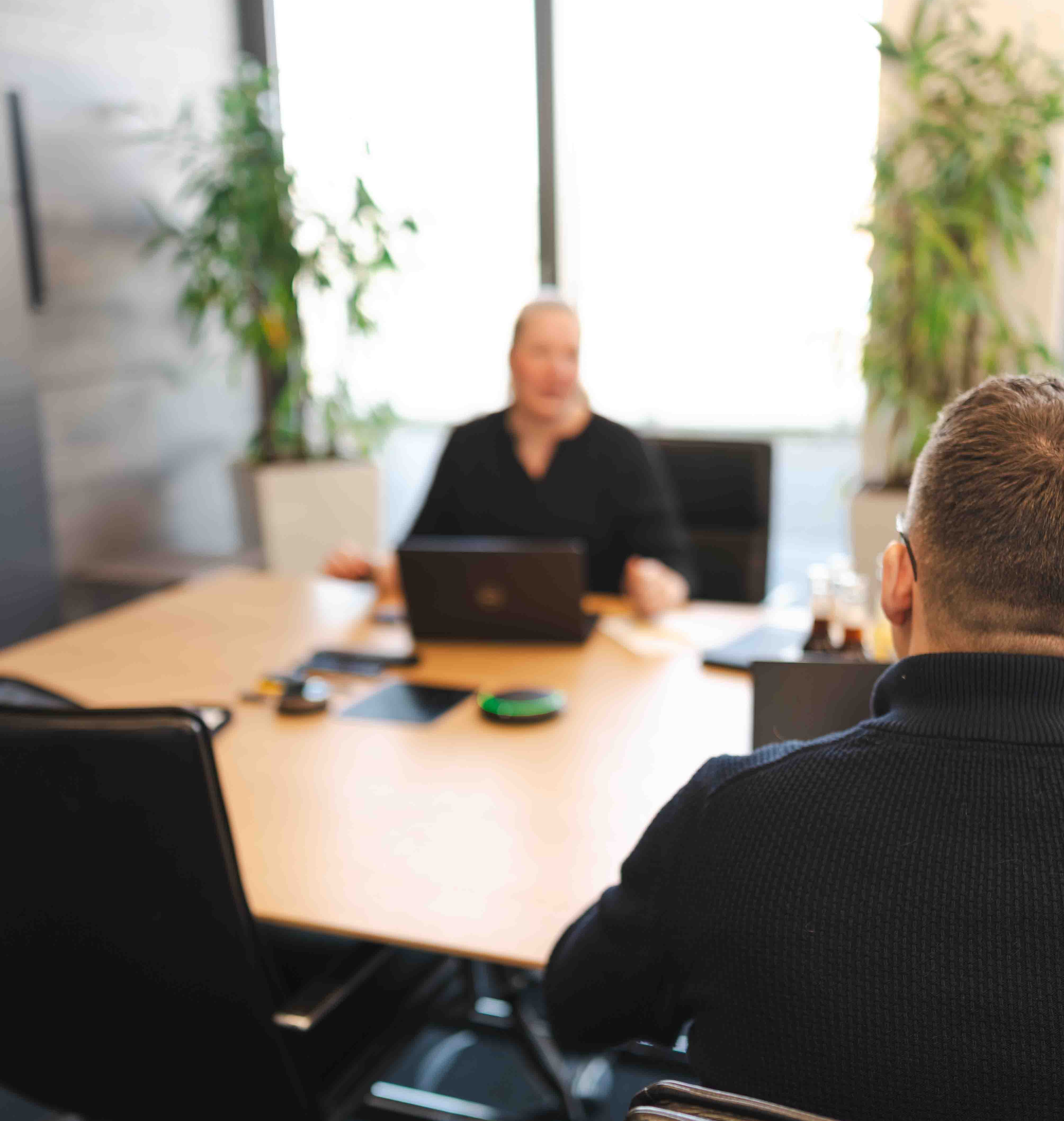Ein Besprechungsraum bei der NOSTA Group, Mitarbeitende diskutieren.