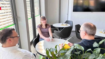 Zwei Personen sitzen an einem Tisch in einem Besprechungsraum