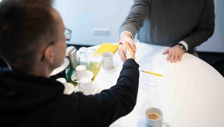 Ein neuer Mitarbeiter wird eingestellt und unterzeichnet den Arbeitsvertrag.