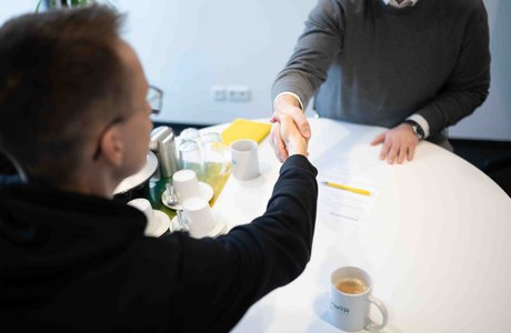 Ein neuer Mitarbeiter wird eingestellt und unterzeichnet den Arbeitsvertrag.