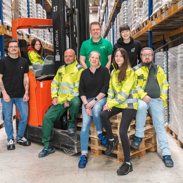 Viele Mitarbeitende der NOSTA Group lächeln auf dem Foto.